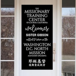 May include: A black and white sign on a white door with the text "The Missionary Training Center of Los Rios, California welcomes Sister Gibson called to serve in the Washington D.C. North Mission Mandarin Speaking 耶穌基督 後期聖徒教會".