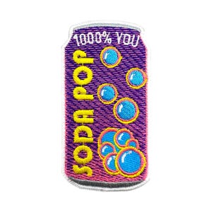 May include: Embroidered patch in the shape of a soda can with the words "Soda Pop" in yellow and "100% You" in white. The can is purple with blue bubbles and yellow outlines.