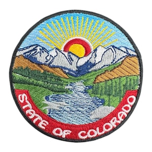 May include: Embroidered patch featuring the Colorado state seal. The design includes a mountain range, a river, and a rising sun. The words "STATE OF COLORADO" are in a red border.