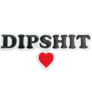 May include: Black embroidered patch with the text "DIPSHIT" and a red heart below.