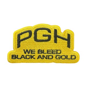 Puede incluir: Parche bordado amarillo con las letras "PGH" en negro. Debajo de las letras, el texto dice "WE BLEED BLACK AND GOLD". El parche tiene una forma curva e irregular.