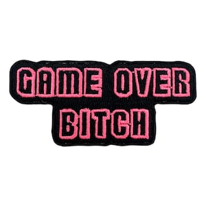 May include: Black and pink embroidered patch with the text "GAME OVER BITCH".