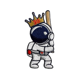 Puede incluir: Un parche bordado de un astronauta que lleva un traje espacial blanco con un casco azul y una corona dorada con el número 30. El astronauta sostiene un bate de béisbol marrón.
