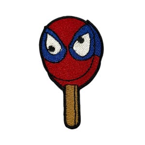 May include: Embroidered patch in the shape of a popsicle, featuring a red face with blue eye coverings and white eyes. The popsicle stick is brown. The patch is likely for clothing or accessories.