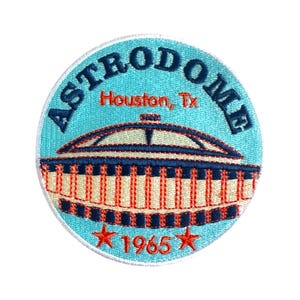 May include: A blue and white embroidered patch with the text "ASTRODOME Houston, Tx 1965" and a stylized image of the Astrodome.