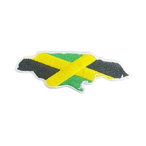 May include: Embroidered patch in the shape of Jamaica, featuring the country's flag. The patch has a white border, with a yellow cross, green and black sections, and is likely for clothing or accessories.