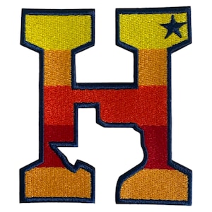 Pode incluir: Uma letra H de feltro azul com um design listrado amarelo, laranja e vermelho. Uma estrela branca está no canto superior direito da letra.