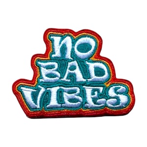 Puede incluir: Un parche bordado colorido con el texto "NO BAD VIBES" en letras blancas con un contorno turquesa y un borde rojo, naranja y amarillo.