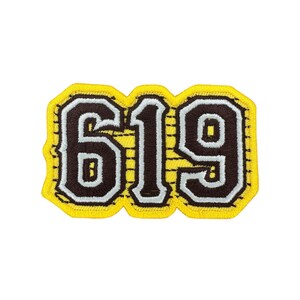 May include: Embroidered patch with the number "619" in a bold, collegiate-style font. The numbers are brown with a white outline, set against a yellow background. The patch has a yellow border with a stitched edge.