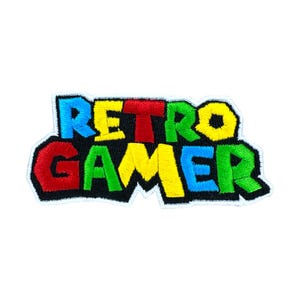 May include: Embroidered patch with the words "RETRO GAMER" in a colorful, blocky font. The text is outlined in black and has a white border. The letters are blue, red, yellow, and green.