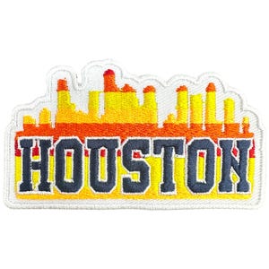 May include: Embroidered patch featuring the city skyline of Houston, Texas. The patch has a white border and displays the city name in navy blue block letters. The skyline is rendered in shades of yellow, orange, and red.