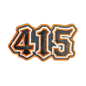 May include: Embroidered patch featuring the number "415" in black, orange, and white. The numbers have a bold, outlined design with a decorative border. The patch is likely for clothing or accessories.