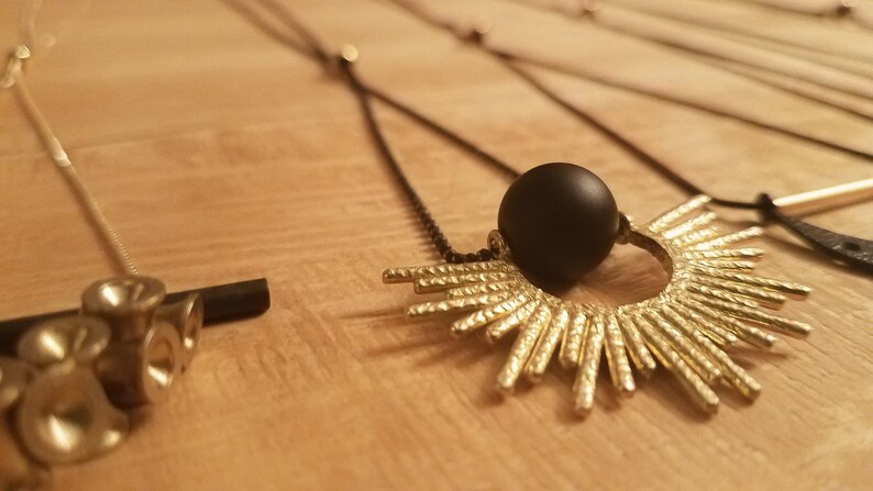 Solar Eclipse original plaything studio design matte onyx ball framed in gold sun