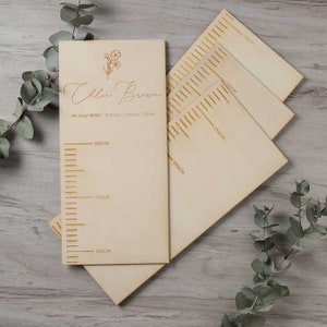 Könnte beinhalten: Ein hölzerner Wachstumsmesser mit einem floralen Design und dem eingravierten Namen "Chloe Brown". Die Tabelle enthält Messungen in Zentimetern von 160 cm bis 180 cm.