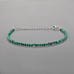 May include: A delicate green malachite gemstone bracelet with a silver chain and clasp.