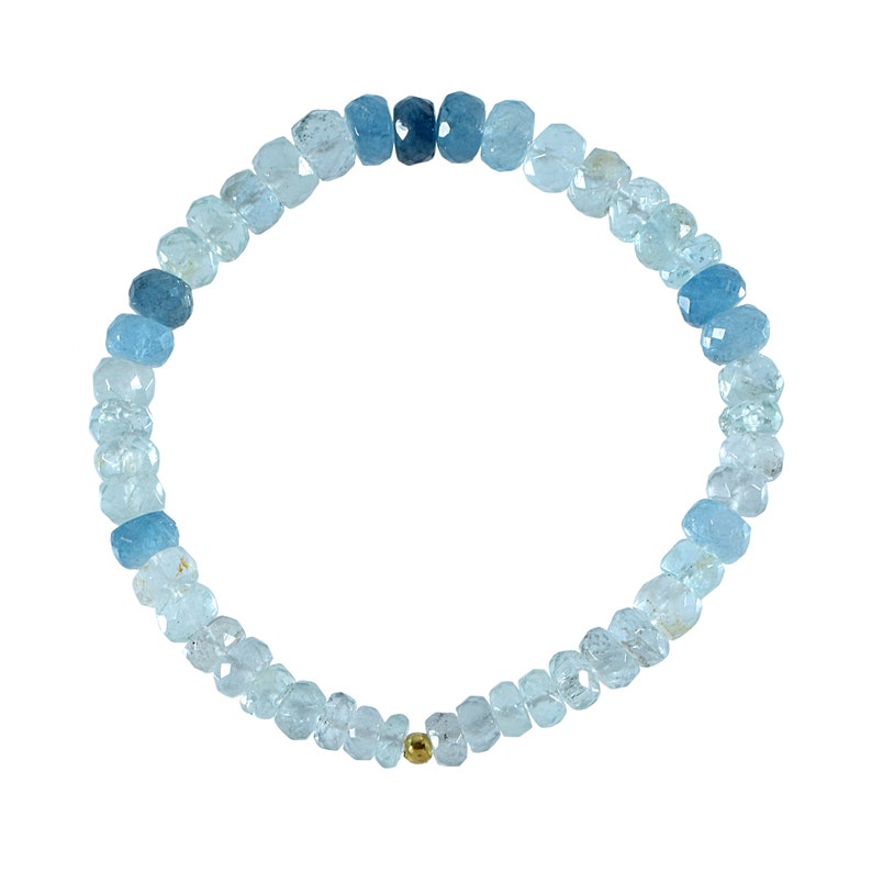 May include: A light blue aquamarine gemstone bracelet with a gold bead accent. The bracelet is made of faceted beads and is strung on a stretchy cord.