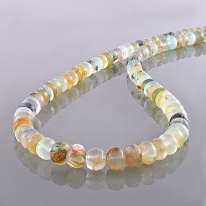 May include: A strand of light green, blue, and brown gemstone beads. The beads are round and have a smooth, polished finish.