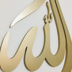 May include: Gold-colored metal wall art featuring the Arabic word "Allah" in a stylized calligraphy design.