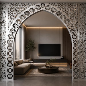 May include: An ornate silver archway with geometric and floral patterns and Arabic script. The arch frames a modern living room with a sofa, coffee table, and a large flat-screen TV. The interior design features neutral tones and a minimalist aesthetic.