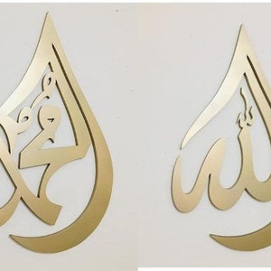 May include: Two gold-colored metal wall decor pieces in the shape of a teardrop. The left piece features the Arabic word "Muhammad" in a decorative script. The right piece features the Arabic word "Allah" in a decorative script.