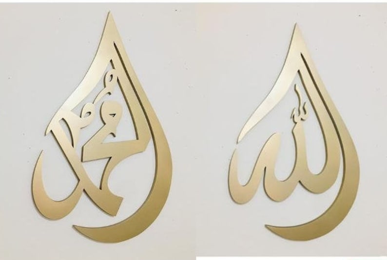 May include: Two gold-colored metal wall decor pieces in the shape of a teardrop. The left piece features the Arabic word "Muhammad" in a decorative script. The right piece features the Arabic word "Allah" in a decorative script.