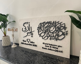 May include: A white canvas with black Arabic calligraphy and text. The text reads "He put between you Love & Mercy Surah Ar-Rum (30:21)" and "Yasir & Aika 25th December 2021".