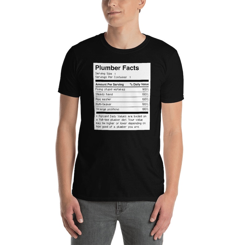 May include: Black t-shirt featuring a white graphic of a nutrition facts label for plumbers. The label lists "Plumber Facts" and includes items such as "Fixing stupid mistakes", "Steady hand", "Pipe master", "Multi-tasker", and "Strange positions", all with a 100% daily value.