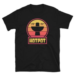 Puede incluir: Camiseta negra con un gráfico retro de una olla caliente con vapor saliendo de ella. El gráfico está sobre un fondo de puesta de sol con colores naranja, rosa y amarillo. El texto "HOTPOT" está escrito en letras amarillas debajo del gráfico.