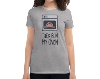 May include: A heather grey t-shirt with a cartoon illustration of a loaf of bread in an oven. The text "Their Bun My Oven" is printed below the illustration.