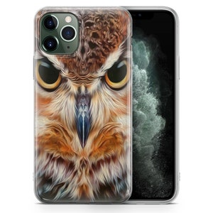 May include: A clear phone case with a close-up image of an owl's face. The owl has brown, orange, and white feathers. The owl's eyes are yellow and black.