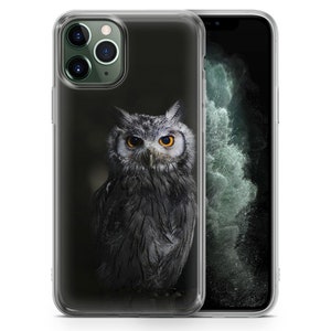 May include: A clear phone case with a black and white image of an owl with yellow eyes. The owl is facing forward and has its wings folded. The phone case is designed for an iPhone.