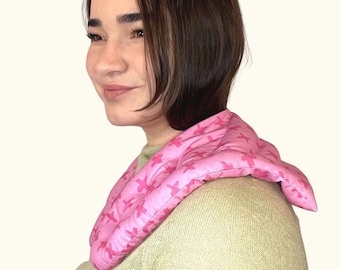 May include: A pink neck wrap with a floral pattern. The wrap is made of soft fabric and is designed to provide comfort and warmth to the neck and shoulders.
