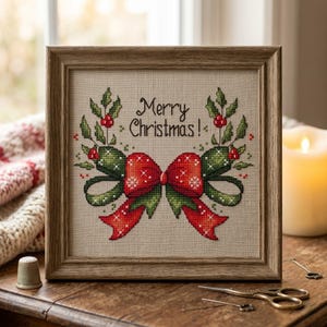 May include: Cross-stitch artwork in a wooden frame. The design features a red bow with snowflake accents and green ribbons, surrounded by holly. The text "Merry Christmas!" is stitched above the bow. The artwork is displayed on a wooden surface.