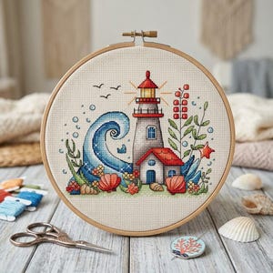 Puede incluir: Bordado de punto de cruz en un aro de madera con un faro, una ola del océano, conchas marinas y follaje. El diseño incluye una casa con tejado rojo, una estrella y pájaros. La paleta de colores incluye azul, rojo, verde y beige.