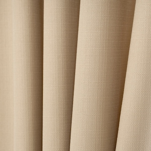 May include: Close-up of a beige fabric with a textured weave. The fabric is folded in a series of pleats, creating a soft and inviting look.