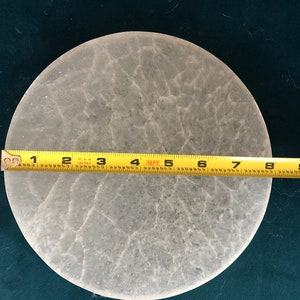 May include: A white, round, textured, decorative plate measuring 8 inches in diameter.
