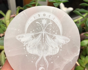 May include: White selenite charging plate with an etched design of a moth and crescent moon.