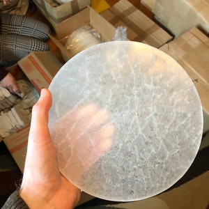 May include: A large, round, clear selenite plate with a textured surface. The plate is approximately 10 inches in diameter.