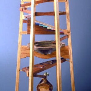 May include: A wooden marble run tower with multiple levels and a winding track. The tower is made of natural wood with a light brown finish. The marble run is a fun and engaging toy for children of all ages.