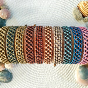Puede incluir: Un conjunto de diez pulseras tejidas de colores con un patrón geométrico. Las pulseras están hechas con una variedad de colores, incluyendo dorado, marrón, naranja, azul verdoso, azul y morado.