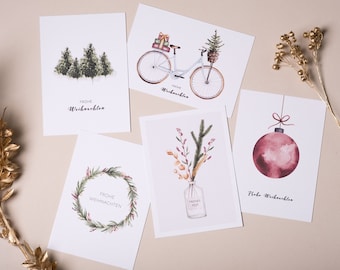 Könnte beinhalten: Eine Sammlung von Weihnachtskarten mit Aquarellmotiven. Die Designs zeigen einen Wald, ein Fahrrad mit Geschenken, einen Kranz, eine Blumenvase und eine rote Christbaumkugel. Jede Karte trägt die Aufschrift "Frohe Weihnachten".