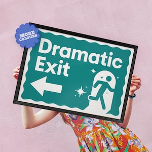 May include: A framed sign with the words "Dramatic Exit" in white on a teal background. The sign features an arrow, a running figure, and star graphics. A blue flower-shaped sticker with "MORE COLOURS" is in the upper left corner.