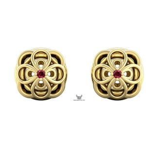 Könnte beinhalten: Ein Paar goldene Ohrstecker mit einem symmetrischen, durchbrochenen Blumenmuster aus abgerundeten, geschlungenen Blütenblättern. Jeder Ohrstecker ist in der Mitte mit einem kleinen, runden, dunkelroten Edelstein besetzt und poliert.