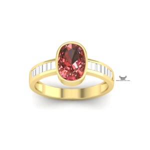 Peut inclure: Une bague en or avec une grosse pierre précieuse rose-rouge de forme ovale au centre. La monture est également en or, avec des pierres précieuses rectangulaires et transparentes de chaque côté de la pierre centrale. Sur fond blanc.