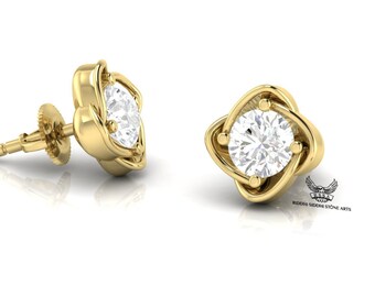 May include: A pair of gold stud earrings with a clear round gemstone set in a four-leaf clover design.