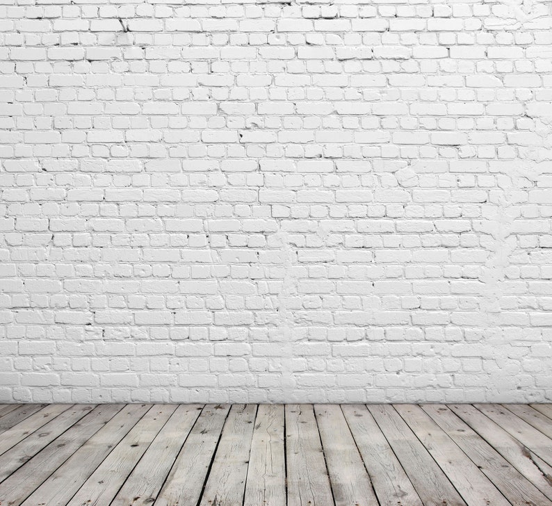 May include: A white brick wall with a wooden floor. The floor is made of light brown wood planks.