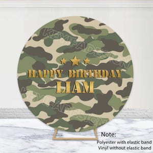 May include: Round camouflage backdrop with gold text that reads "Happy Birthday Liam".