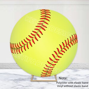 Pode incluir: Uma grande bola de softball amarela e vermelha com costuras brancas. A bola de softball está em um suporte de madeira. Nota: Poliéster com banda elástica, vinil sem banda elástica.