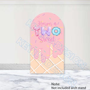 May include: An arched backdrop cover featuring a pink ice cream cone design with a waffle pattern at the base. The text reads Harper is TWO Sweet, with the word TWO stylized as colorful donuts and sprinkles scattered across the pink surface.