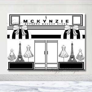 Op de afbeelding: Zwart-witte illustratie van een winkel met de tekst "MCKYNZIE SEPHORA MAKEUP STORE". De winkel heeft twee grote ramen, twee deuren en twee luifels met strikken. Er staan ​​mannequins in de ramen die jurken dragen en een Eiffeltoren in het midden van de winkel.